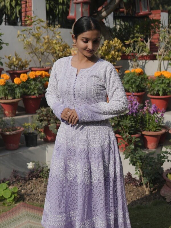 Woman in purple dress among flowers.